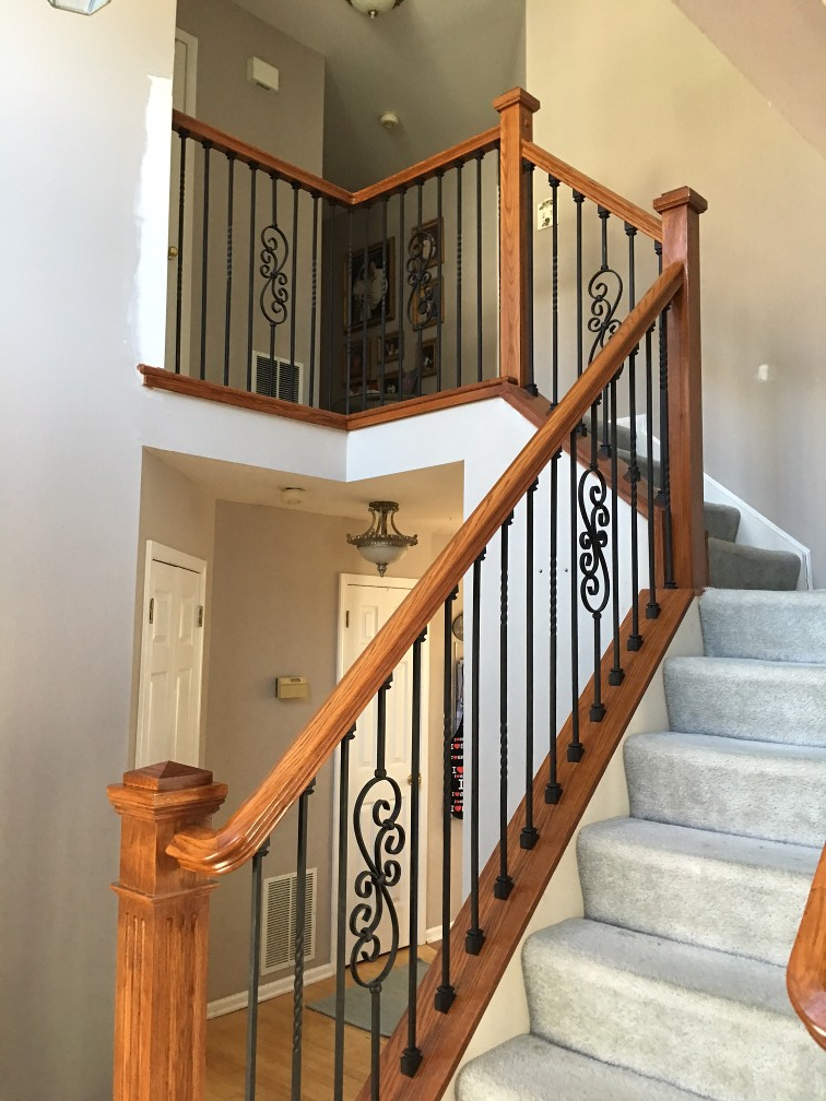 A staircase with wooden work inside the room painted in white, enhancing the room's brightness and modern aesthetic